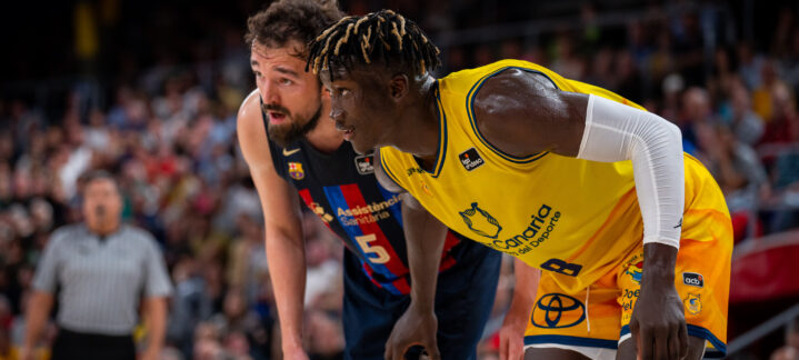 Jugadores de baloncesto en acción durante un partido en el Palau Blaugrana.