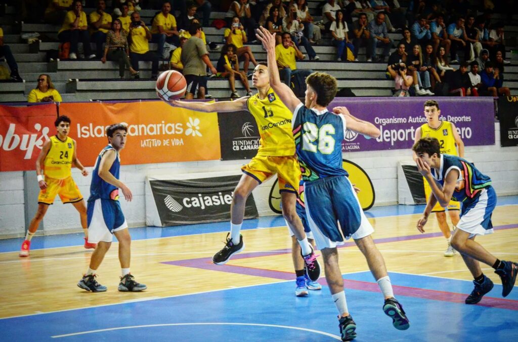 Jugadores de baloncesto compiten en un partido en la cancha, destacando en acción.