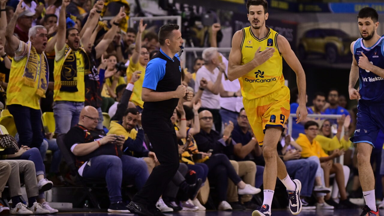 Jugadores y aficionados animan en un emocionante partido de baloncesto.