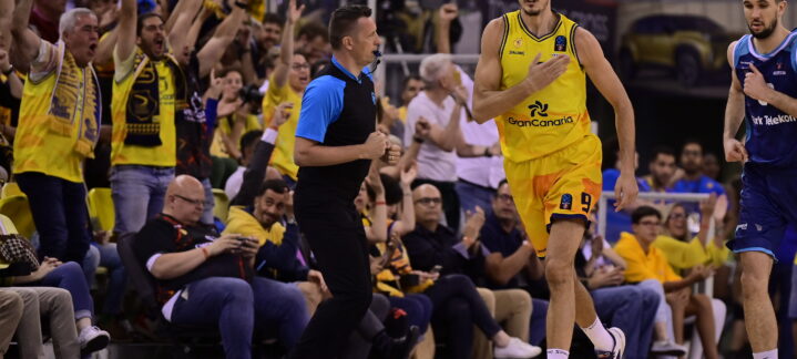 Jugadores y aficionados animan en un emocionante partido de baloncesto.