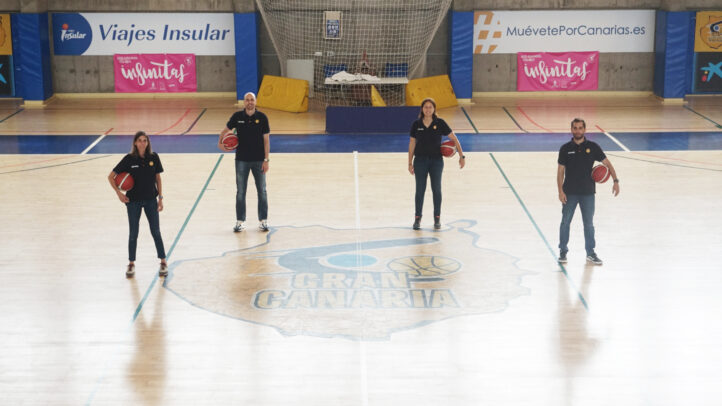 Cuatro entrenadores de baloncesto posando en una pista con el logo del CB Gran Canaria.