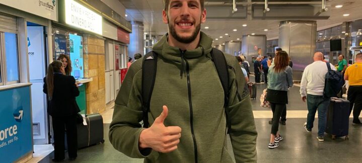 a su llegada: ""Puedo aportar energía a ambos lados de la pista""","Jugador de baloncesto sonriente en el aeropuerto, con equipaje y gesticulando un pulgar hacia arriba.