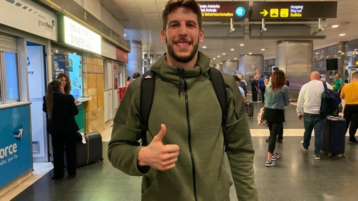 a su llegada: ""Puedo aportar energía a ambos lados de la pista""","Jugador de baloncesto sonriente en el aeropuerto, con equipaje y gesticulando un pulgar hacia arriba.