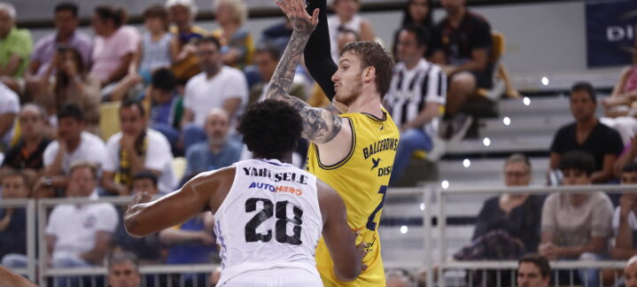 Balcerowski lanza a canasta mientras Yarusele defiende en un partido de baloncesto.