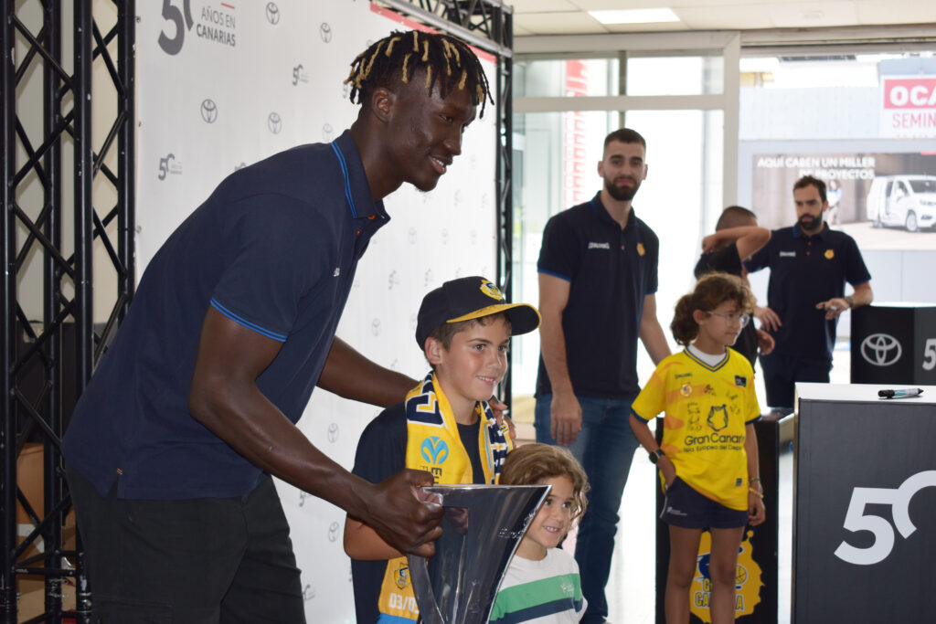 Vítor Benite y Jovan Kljajic, protagonistas en un 'meet&greet' en Toyota Canarias",Khalifa Diop posa junto a niños en un evento del Club Baloncesto Gran Canaria.