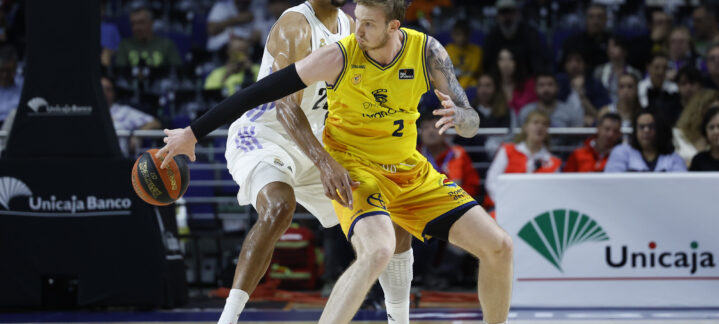 Dos jugadores de baloncesto compiten en la cancha durante un partido emocionante.