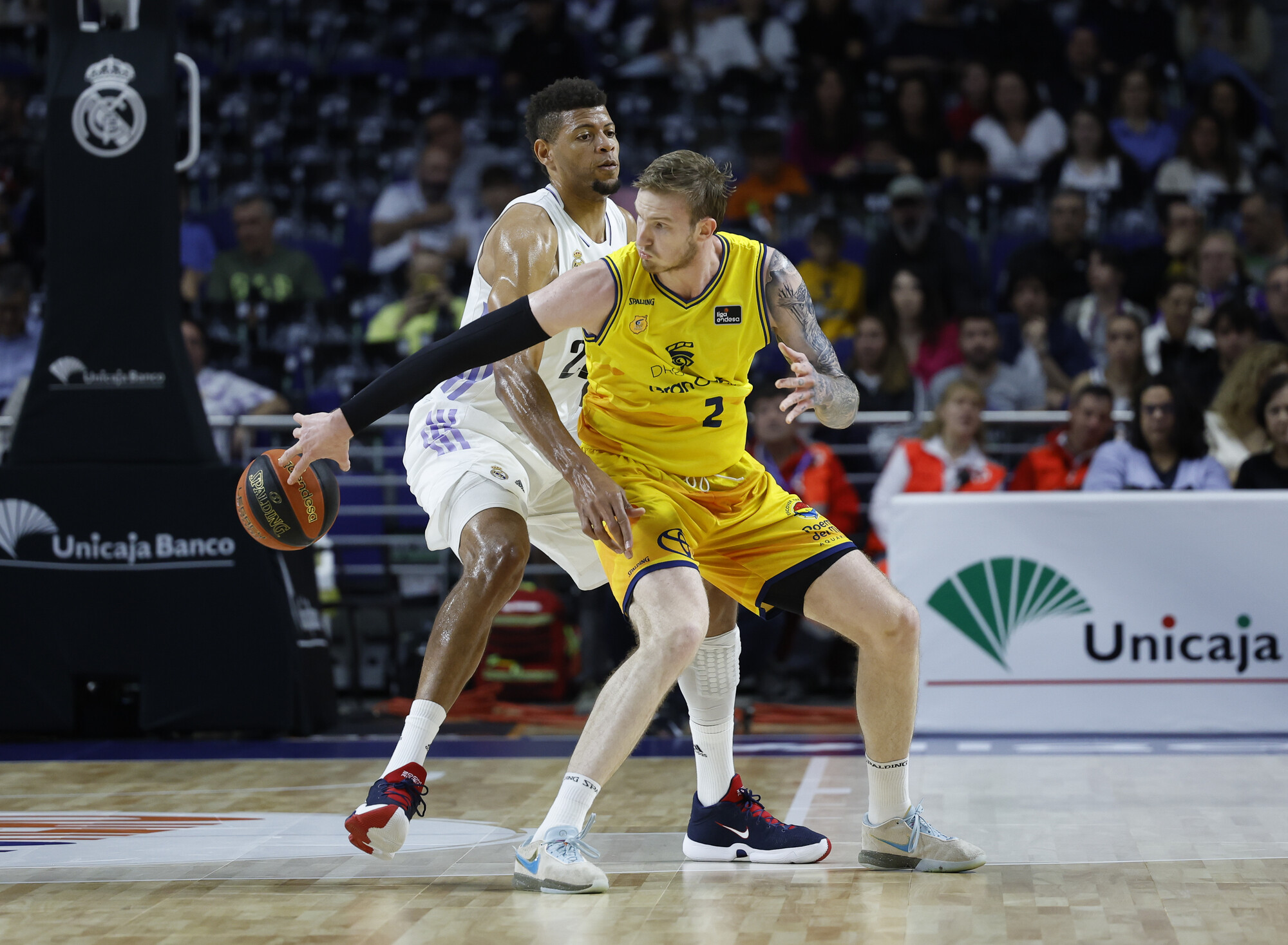 Dos jugadores de baloncesto compiten en la cancha durante un partido emocionante.