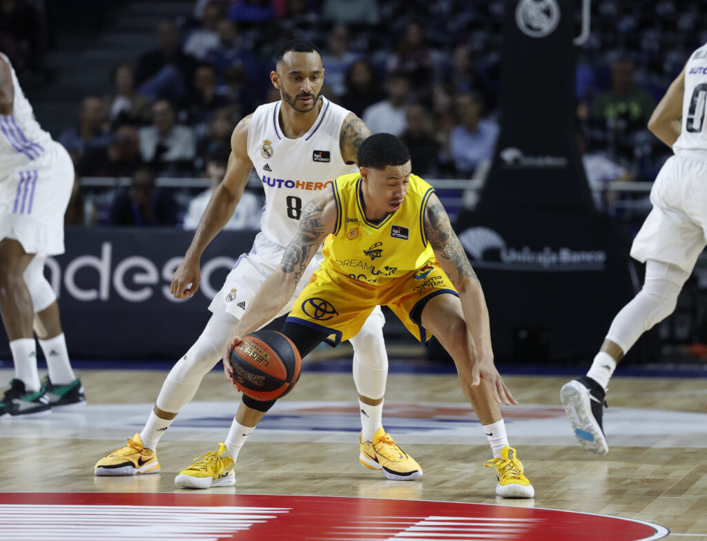Jugadores del Dreamland Gran Canaria y Real Madrid en acción durante un partido de baloncesto.