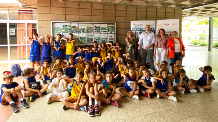 Grupo de niños en ropa deportiva, posando con representantes del CB Gran Canaria.