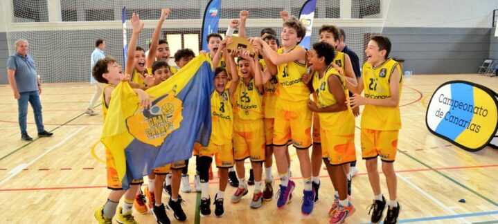Jugadores del minibasket masculino del Gran Canaria celebran su campeonato con una bandera.