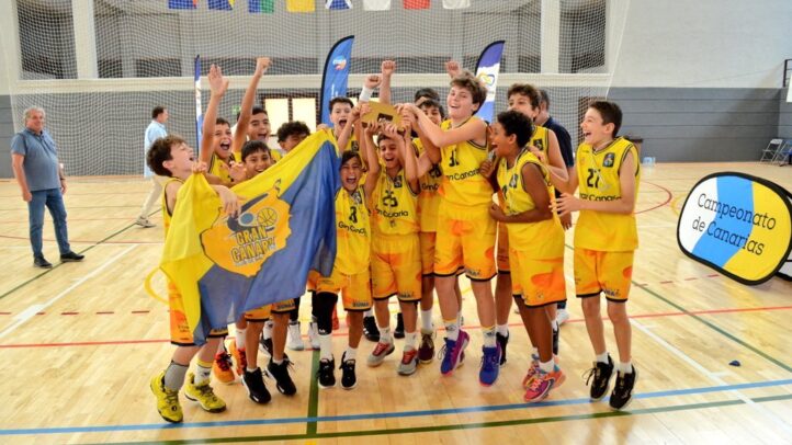 Jugadores del minibasket masculino del Gran Canaria celebran su campeonato con una bandera.