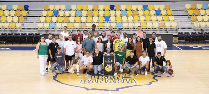 Grupo de voluntarios posando en la cancha del Club Baloncesto Gran Canaria con un trofeo.