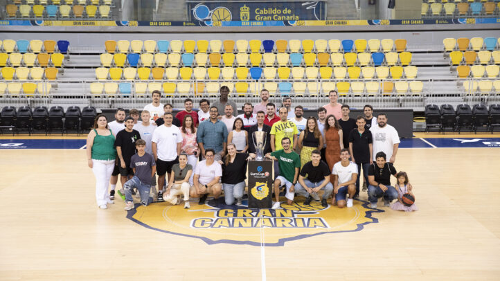Grupo de voluntarios posando en la cancha del Club Baloncesto Gran Canaria con un trofeo.