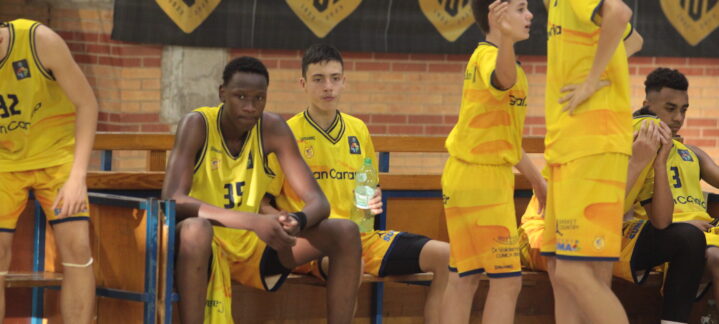 Jugadores del Gran Canaria infantil en el banquillo, mostrando concentración y esfuerzo.