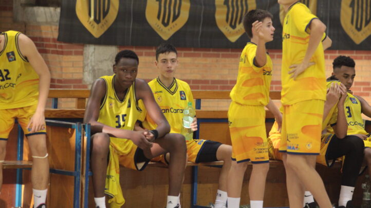 Jugadores del Gran Canaria infantil en el banquillo, mostrando concentración y esfuerzo.
