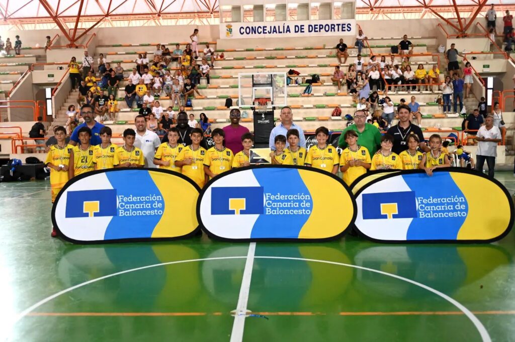 Equipo de preminibasket masculino del Gran Canaria con entrenadores y banners al finalizar el curso.