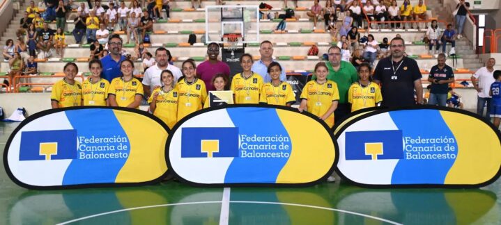 Jugadoras del Gran Canaria Claret preminibasket femenino con entrenadores y trofeo en pista.
