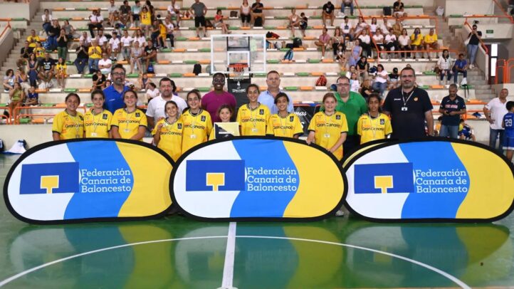 Jugadoras del Gran Canaria Claret preminibasket femenino con entrenadores y trofeo en pista.
