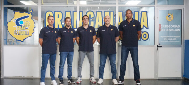 Grupo de cinco personas en uniforme del CB Gran Canaria, frente a una pared con el logo del club.