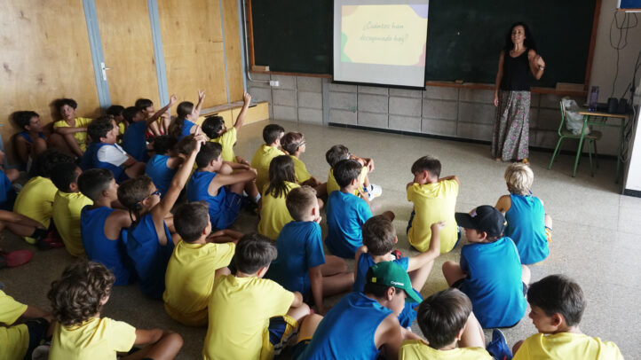 Grupo de niños escuchando a una instructora en el Campus de Verano CaixaBank.