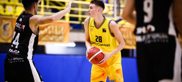 Jugador del Gran Canaria con balón, frente a un rival que intenta defender.