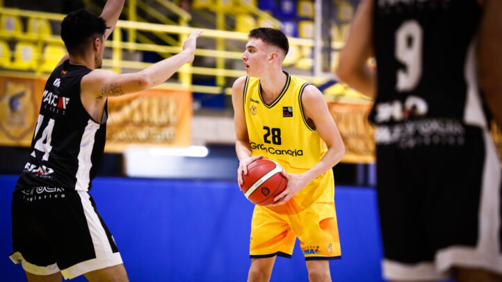 Jugador del Gran Canaria con balón, frente a un rival que intenta defender.