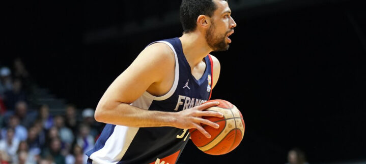 Jugador sosteniendo un balón de baloncesto, en acción durante un partido.