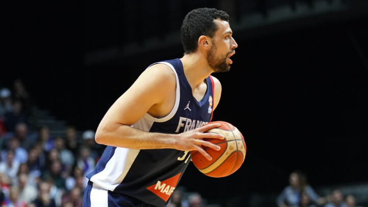 Jugador sosteniendo un balón de baloncesto, en acción durante un partido.