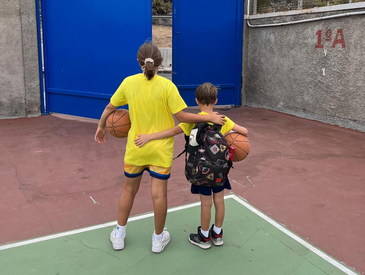 Niños con balones de baloncesto en un campo, listos para participar en un campus.