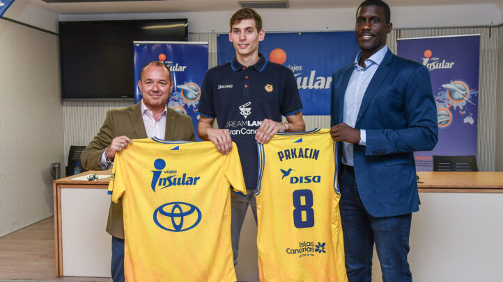 presentado en el Gran Canaria Arena junto a Viajes Insular",Roko Prkacin sostiene su camiseta del Gran Canaria junto a dos representantes del club.
