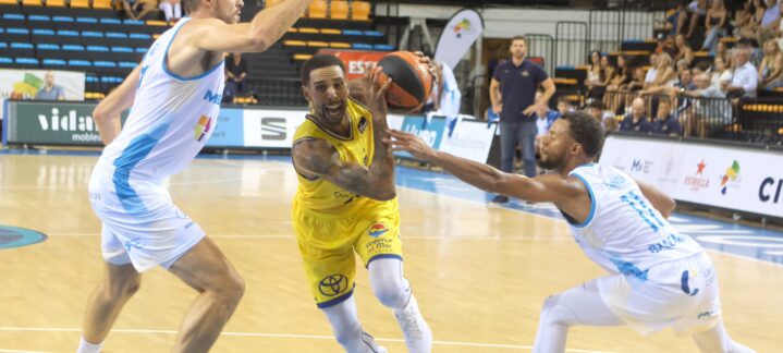 Jugadores en acción durante un amistoso de pretemporada de baloncesto.