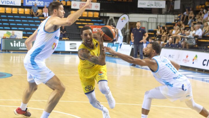 Jugadores en acción durante un amistoso de pretemporada de baloncesto.