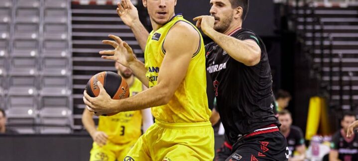 Jugadores de baloncesto compiten por el balón en un partido en Granada.