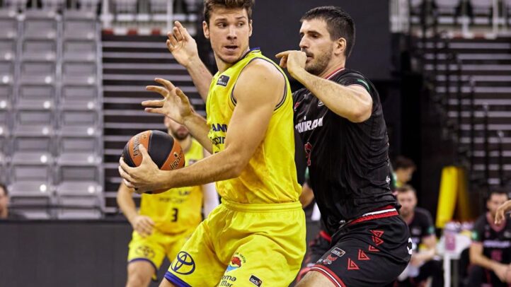 Jugadores de baloncesto compiten por el balón en un partido en Granada.