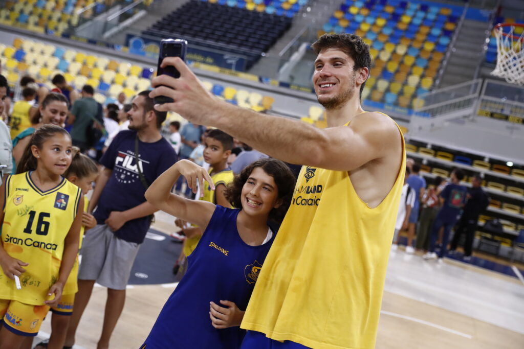 Jugadores del Dreamland Gran Canaria posan sonrientes con jóvenes aficionados.
