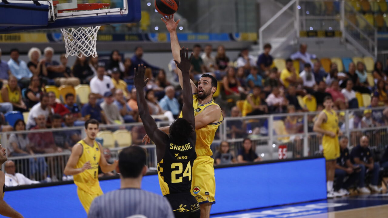 Jugador en acción lanzando a canasta durante un partido en el Gran Canaria Arena.