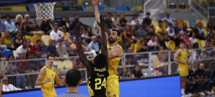 Jugador en acción lanzando a canasta durante un partido en el Gran Canaria Arena.