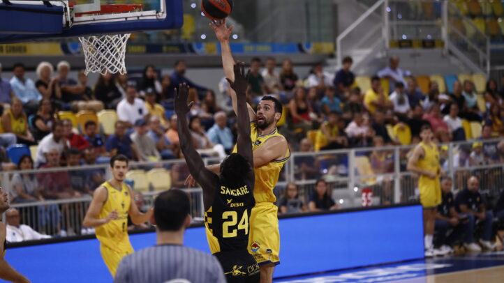 Jugador en acción lanzando a canasta durante un partido en el Gran Canaria Arena.