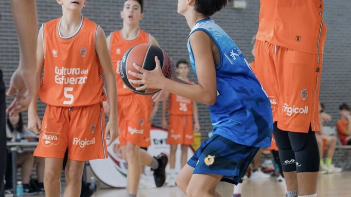 Jugadores infantiles de baloncesto compiten en un torneo, lanzando y defendiendo.