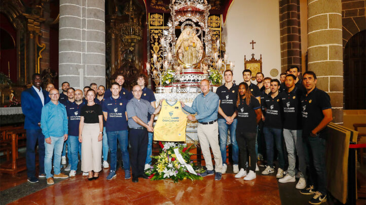 Ofrenda floral del equipo Dreamland Gran Canaria a la Virgen del Pino en una iglesia.