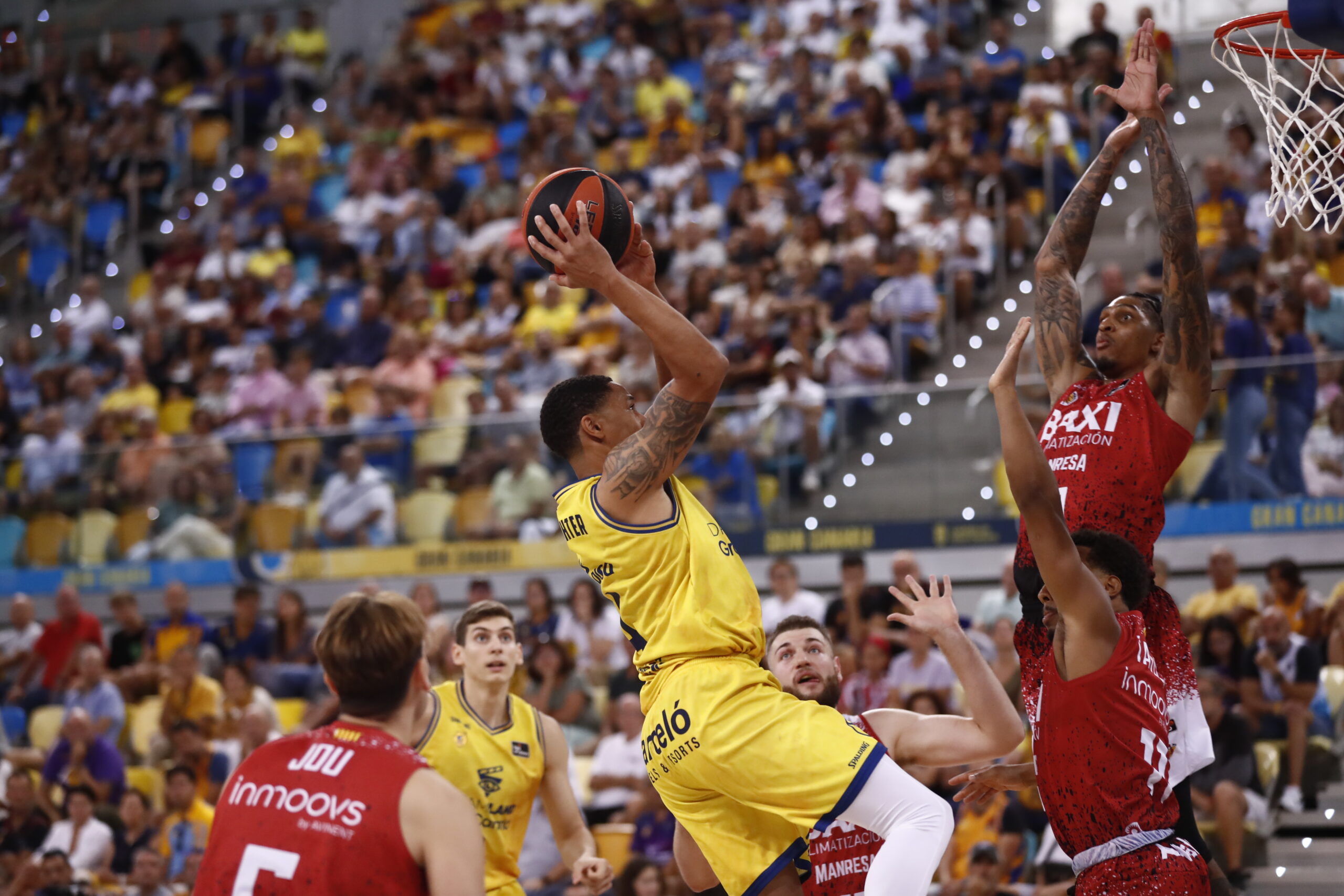 Jugador del CB Gran Canaria lanzando a canasta durante un partido en el estadio.
