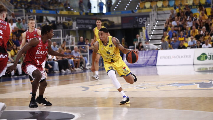 Jugador driblando el balón en un partido de baloncesto en el Gran Canaria Arena.