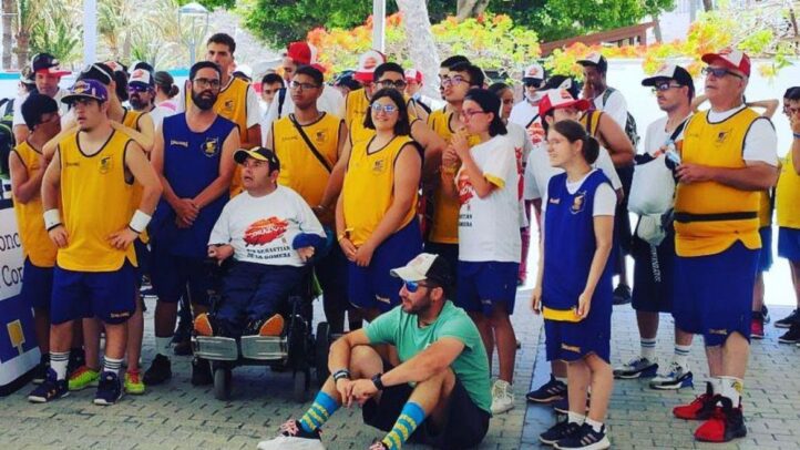Grupo de jóvenes y adultos en camisetas de baloncesto, en un evento al aire libre.