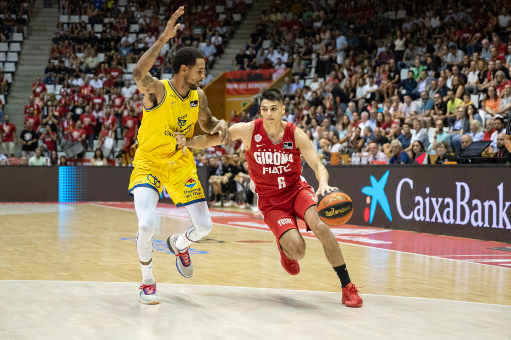 Jugador del Girona con balón driblando, mientras un rival del Gran Canaria lo defiende.