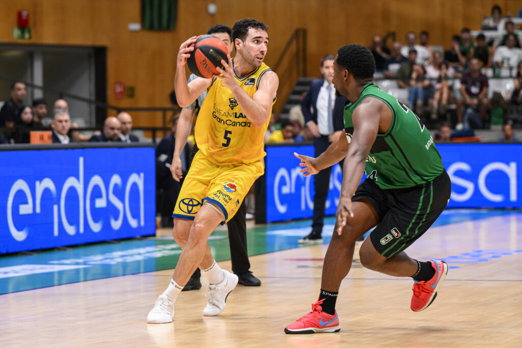 Jugador del Gran Canaria driblando con el balón, enfrentándose a un rival del Joventut.