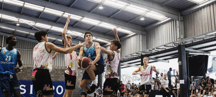 Jugadores compiten por el balón en un partido de baloncesto en el torneo U16.