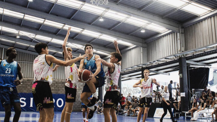 Jugadores compiten por el balón en un partido de baloncesto en el torneo U16.
