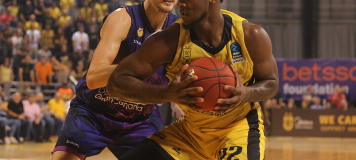 Jugadores de baloncesto compiten por el balón en un intenso partido en Salónica.