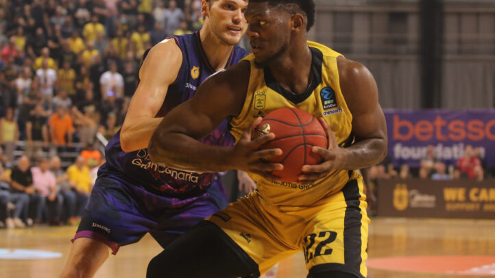 Jugadores de baloncesto compiten por el balón en un intenso partido en Salónica.