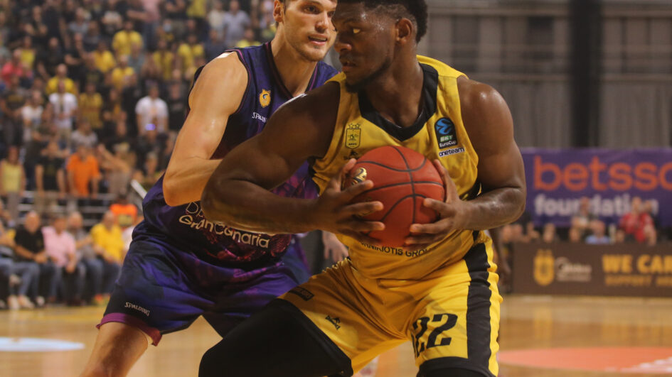 Jugadores de baloncesto compiten por el balón en un intenso partido en Salónica.